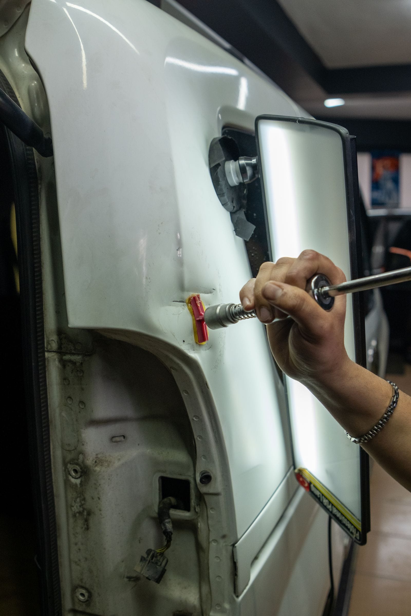 Dent-repair tools positioned on a vehicle body panel