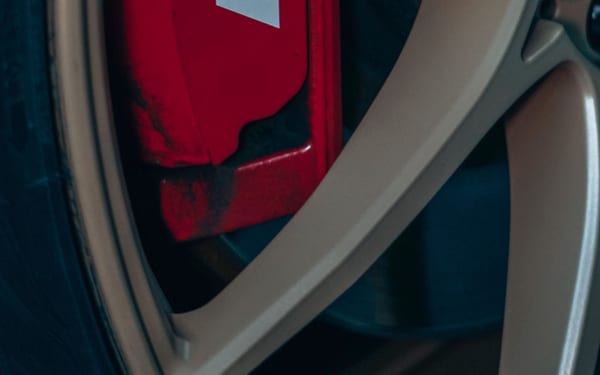 A red brake caliper visible through a car's alloy wheel