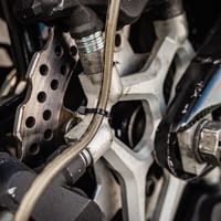 A braided brake line connected to a wheel's brake caliper
