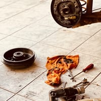 A disassembled brake drum and tools on a workshop floor