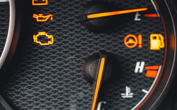 A car dashboard with several warning lights lit, including the engine light