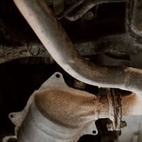 Close-up of a car's exhaust and catalytic converter underneath