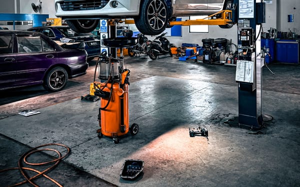 A car raised on a lift over an oil-change service pit