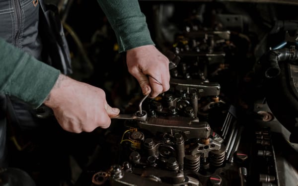 A mechanic's hands using a wrench on an engine