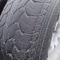 Close-up of a frost-covered winter tire tread